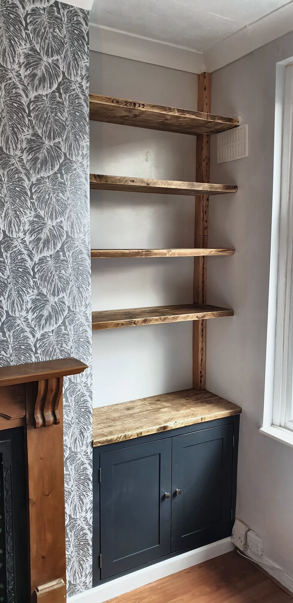 Navy alcove cupboard beneath reclaimed timber shelves