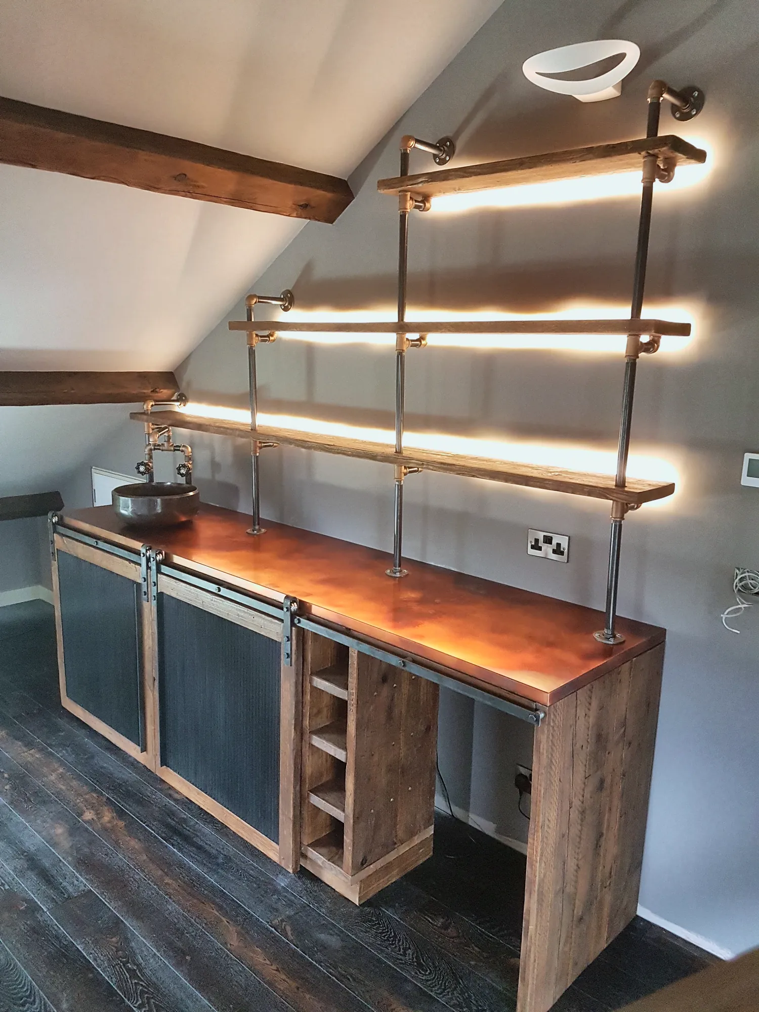 Lit pipe shelving above the vanity