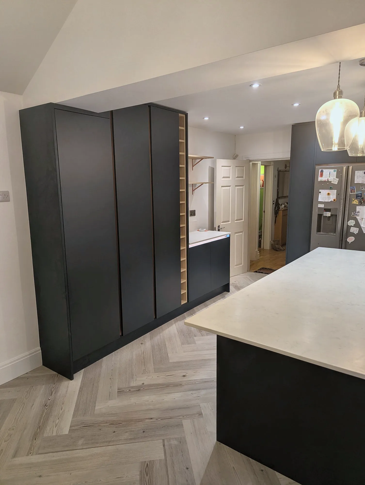 Tall navy units with a slim oak wine rack