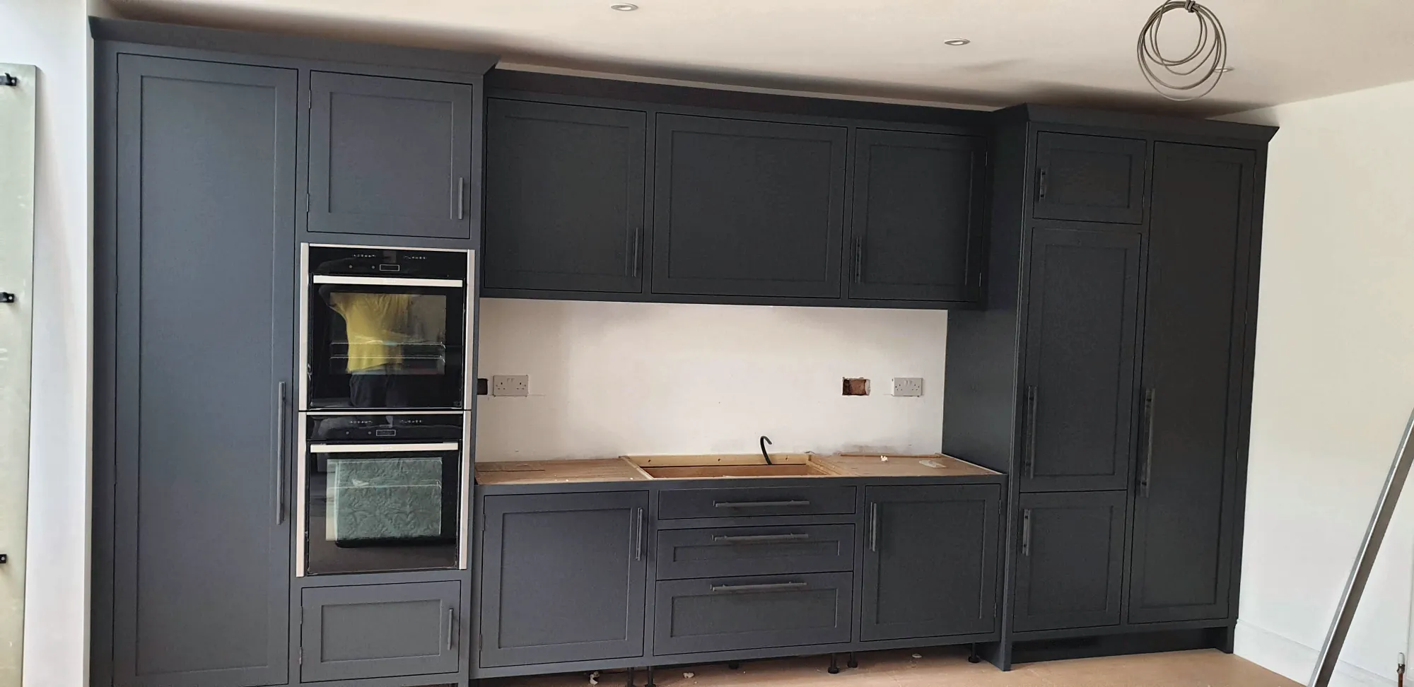 Navy Shaker kitchen with double ovens and oak worktops