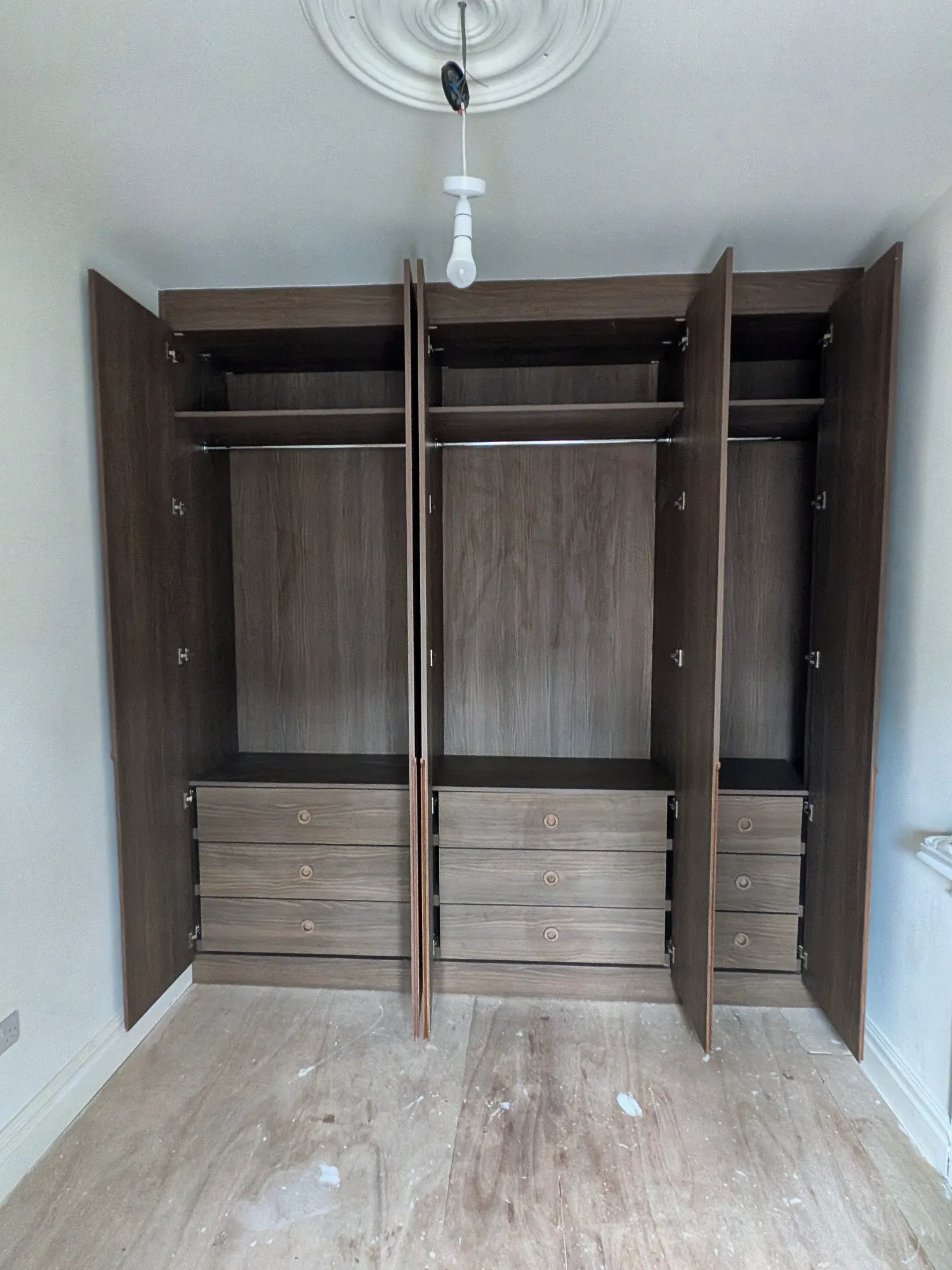 Open wardrobe with hanging rails and drawers
