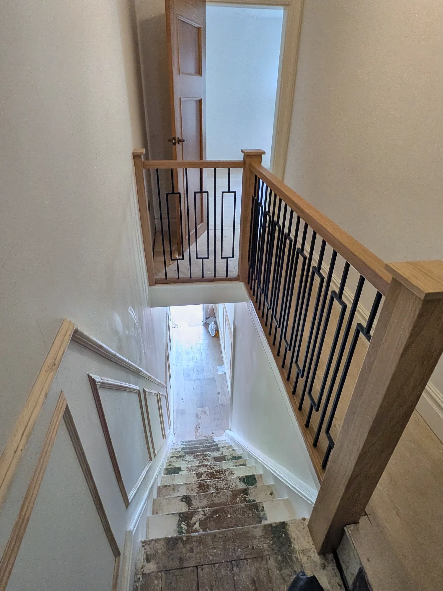 Staircase with an oak handrail and geometric balustrade