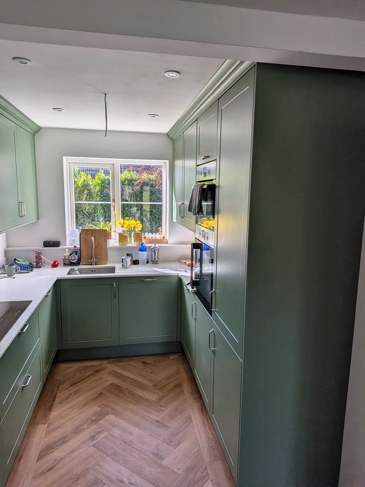 U-shaped sage kitchen with a tall larder