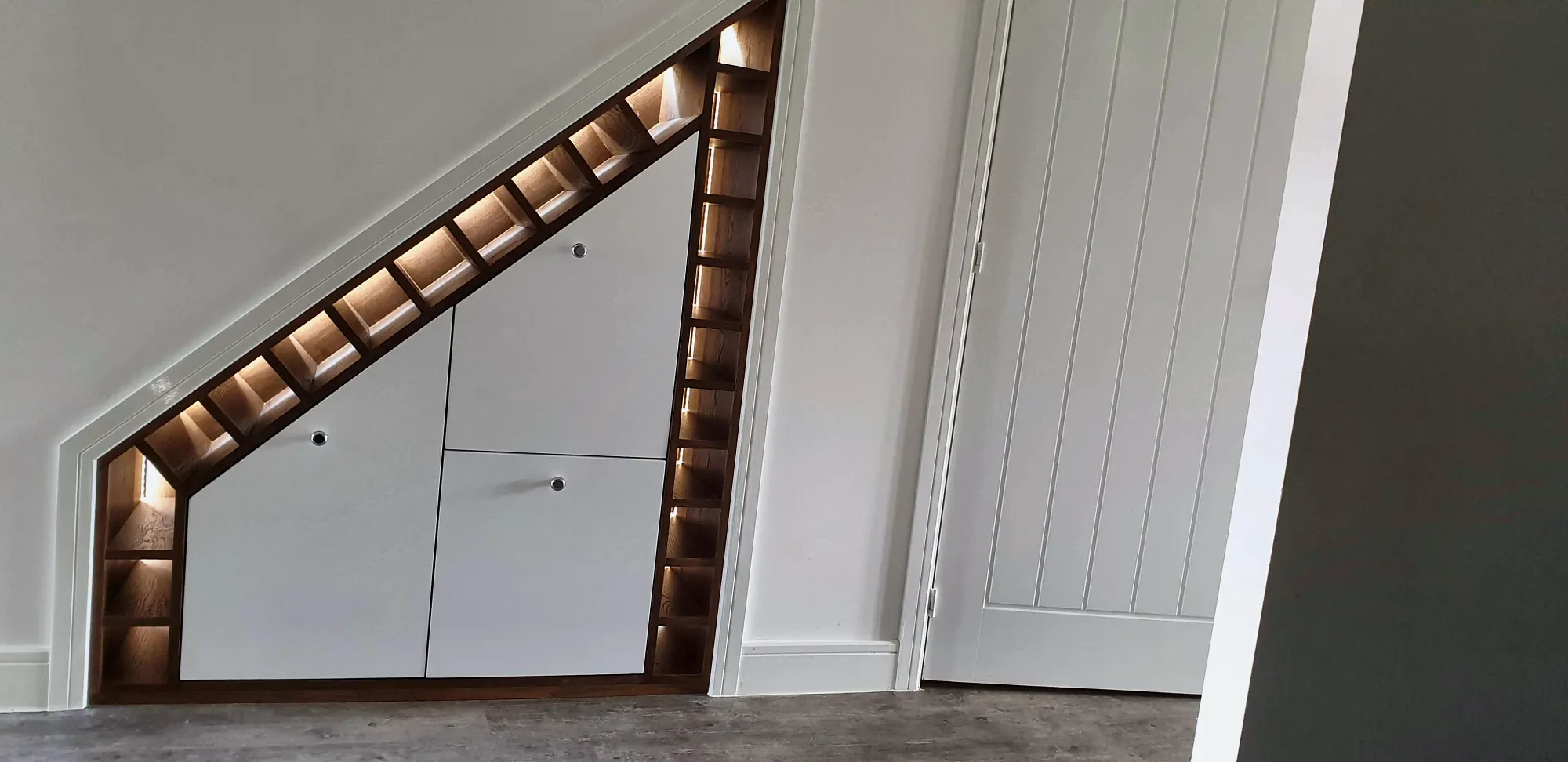 Under-stairs cupboards with a lit wine rack
